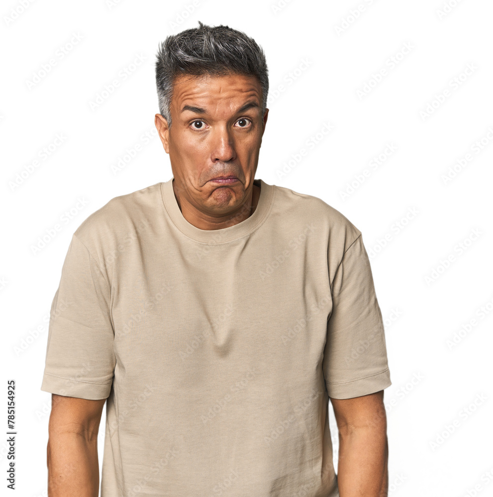 Obraz premium Middle-aged Latino man shrugs shoulders and open eyes confused.