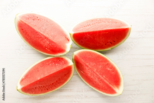 Slices of watermelon on white wooden table.