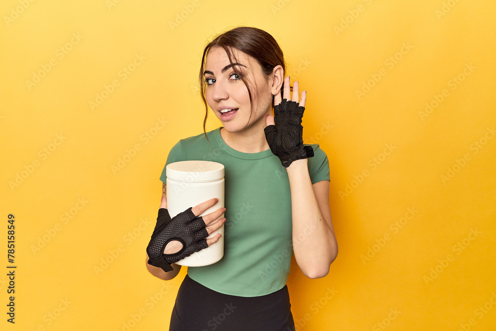 Φωτογραφία Fit woman holding a protein shake trying to listening a gossip.