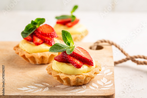 Tablou pe pânză Homemade Strawberry tartlets with vanilla pastry cream - mini fruit tarts filled with custard vanilla pastry cream in a cookie crust