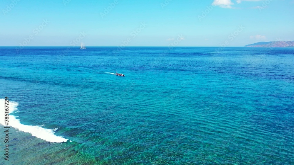 Aerial view of boat floating on sea under blue bright sky