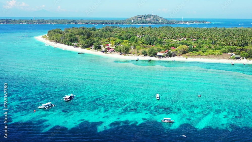 Obraz premium Aerial view of island surrounded by emerald water in Maldives