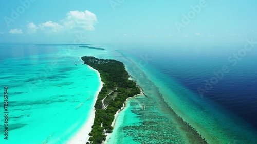 Aerial view of island surrounded by emerald water in Maldives