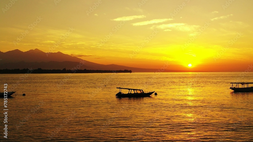 Beautiful view of boats in a sea under the clear sky during sunset in Asia
