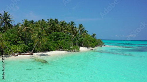 Scenic view of an island covered with greenery against a turquoise sea on a sunny day © Wirestock