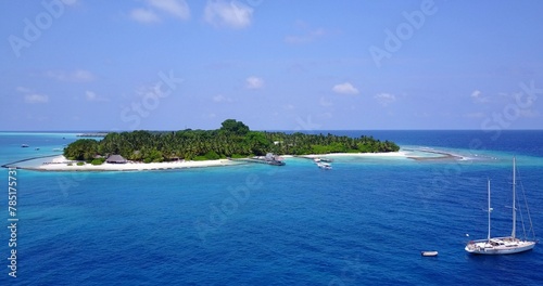 Aerial view of a small island with trees in the middle of the ocean © Wirestock