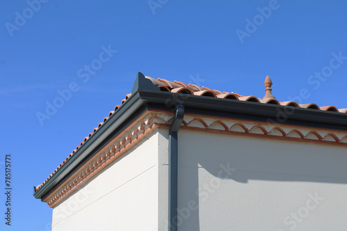 Gouttière aluminium gris anthracite sur la façade de la maison, corniche, génoise, descentes rectangulaires