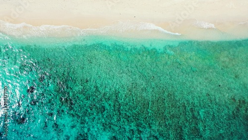 Aerial view of a turquoise sea with soft sands beach in an island of Maldives, Asia