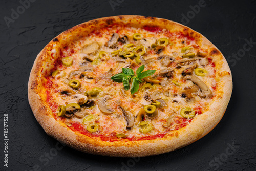 Freshly baked mushroom and olive pizza on black background