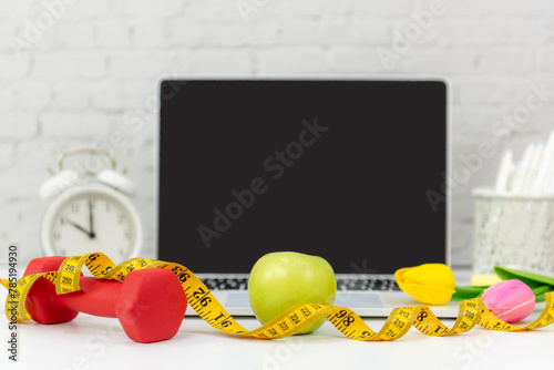 Close up dumbbell.  Healthy snack for diet planning for working in office.  Fresh  fruit with green fruit and tape measure Laptop background.  Healthy Lifestyle Concept