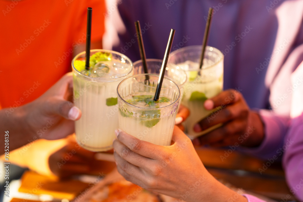 Group of friends, meeting at birthday party, hands clinking cocktails, sitting in cafe Group of friends, meeting at birthday party, hands clinking cocktails, sitting in cafe