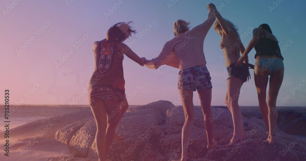 Fototapeta premium Image of light and shapes moving over diverse group of friends at beach