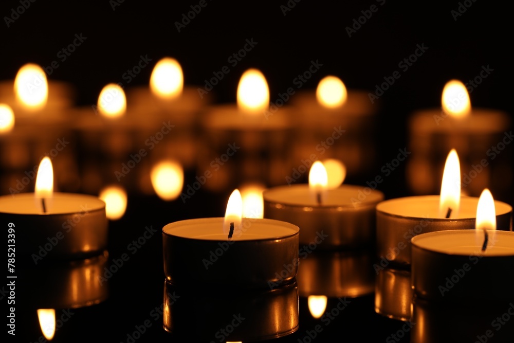 Burning candles on surface in darkness, closeup Burning candles on surface in darkness, closeup