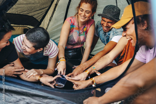 Group of friends playing a fun drinking game in a festival tent photo