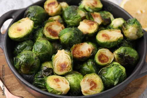 Delicious roasted Brussels sprouts in baking dish on table, closeup