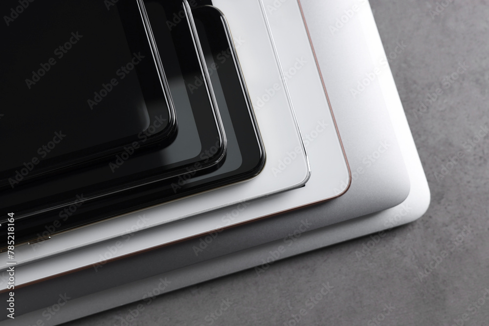 Many different modern gadgets on grey table, closeup Many different modern gadgets on grey table, closeup