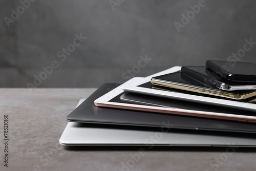 Many different modern gadgets on grey table. Space for text