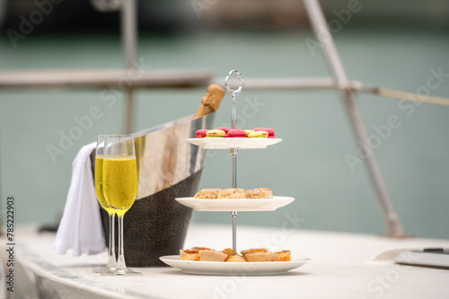 Rich man sleep lying in yacht ship for eat Afternoon tea and champagne . yachting man relax with cake stand decorate catering banquet services with champagne in sea and sunlight