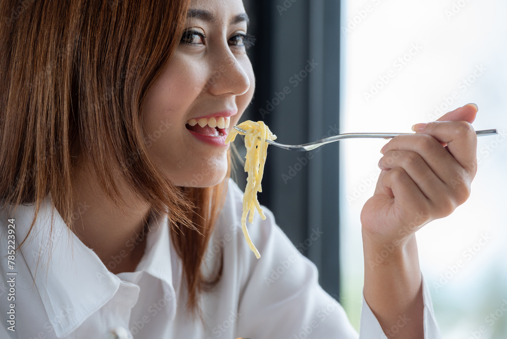 Woman in white clothes holding and smell white dish plate with pasta homemade spaghetti marinara in restaurant background. Lady smell and eat pasta spaghetti by fork. Woman in white clothes holding and smell white dish plate with pasta homemade spaghetti marinara in restaurant background. Lady smell and eat pasta spaghetti by fork.