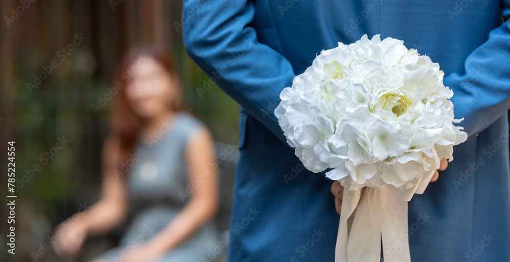 Lover propose marriage hide white rose in hands for surprise romantic date at valentine. Two lover holding rose symbol for show love and propose marriage with asian woman. Lover propose marriage hide white rose in hands for surprise romantic date at valentine. Two lover holding rose symbol for show love and propose marriage with asian woman.