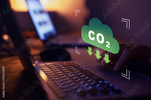 Lower CO2 emissions to limit global warming and climate change. Concept with icon on virtual screen. photo