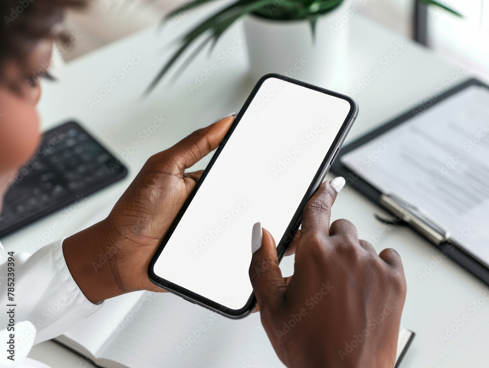 Close-up of a businessman hand holding a mockup smartphone white screen is blank the background is blurred