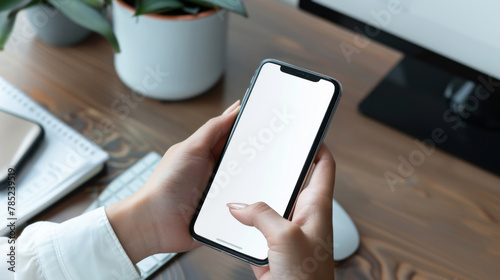 Close-up of a businessman hand holding a mockup smartphone white screen is blank the background is blurred