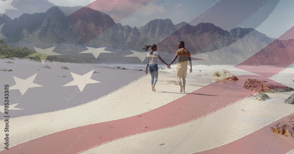 Fototapeta premium Image of american flag moving over couple holding hands and walking on beach
