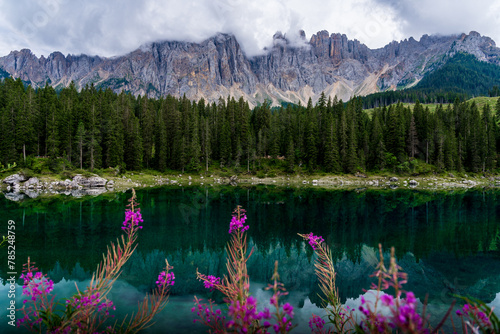 Shot of Karerse lake in Dolomites italy surrounded by high peaks and forest.
 photo