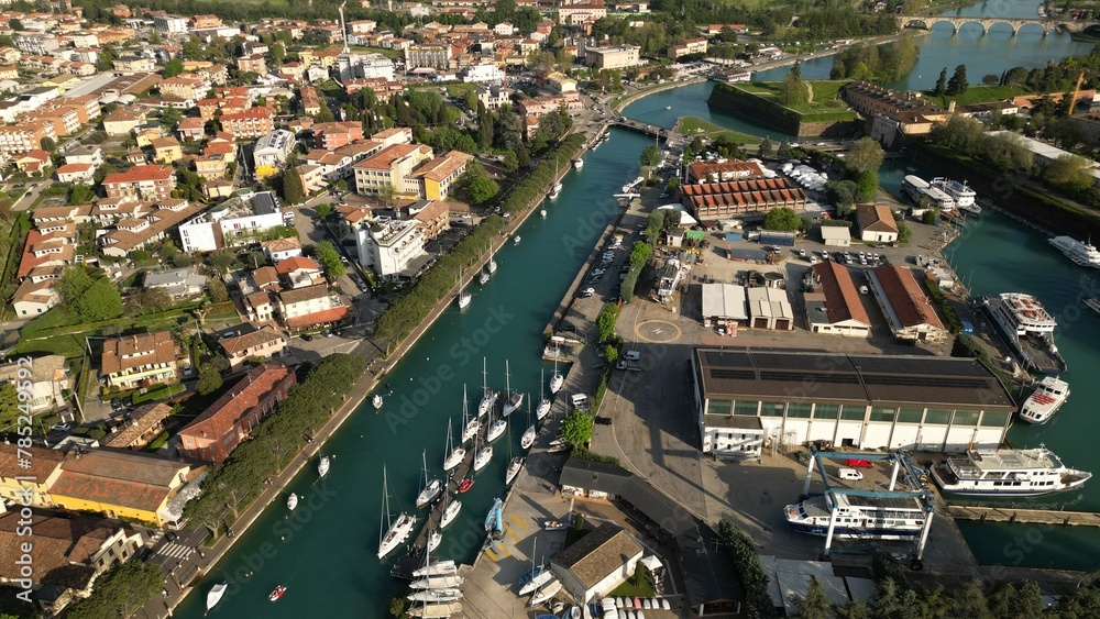 Obraz premium Aerial view of the city of Peschiera del Garda, Verona, Veneto. Top view of the canal with yachts
