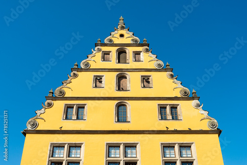 Yellow facade of a typical residential building in Dinkelsbuhl, Franconia, Germany. Perfect blue sky on the background. photo