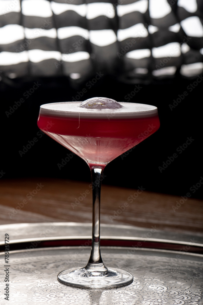 Cocktail in a martini glass on a dark background.