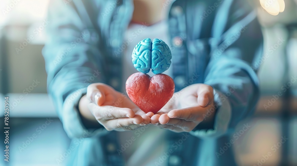 Conceptual image of hands holding a red heart and a brain, representing the balance between emotions and logic - obrazy, fototapety, plakaty 