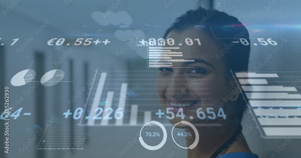 Fototapeta premium Image of financial data and graphs over happy biracial female doctor