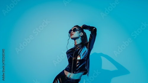 Elegant young woman in blue latex on blue background