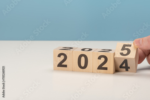 2025 happy new year concept, Flipping of wooden cube block change from 2024 to 2025. Wooden cube with flip over block 2024 to 2025 number. Business management, Inspiration to success ideas and goals.