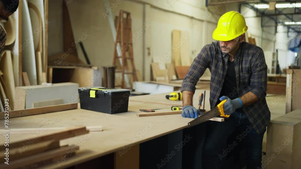 Professional carpenter or woodworker or charpentier man use saw to cut wood stick to small piece to prepare for wood product.