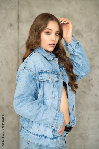 beautiful young woman with long hair in jeans and jacket posing