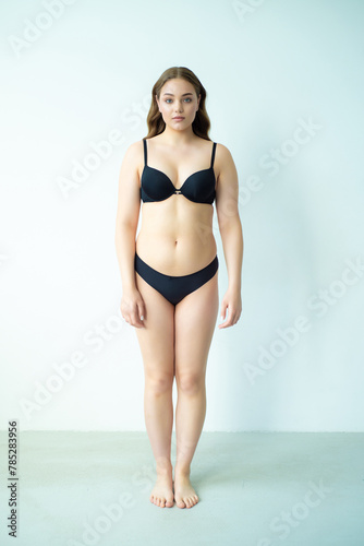 young woman with beautiful hair in black lingerie posing isolated on white background. Model test, snap, polaroid