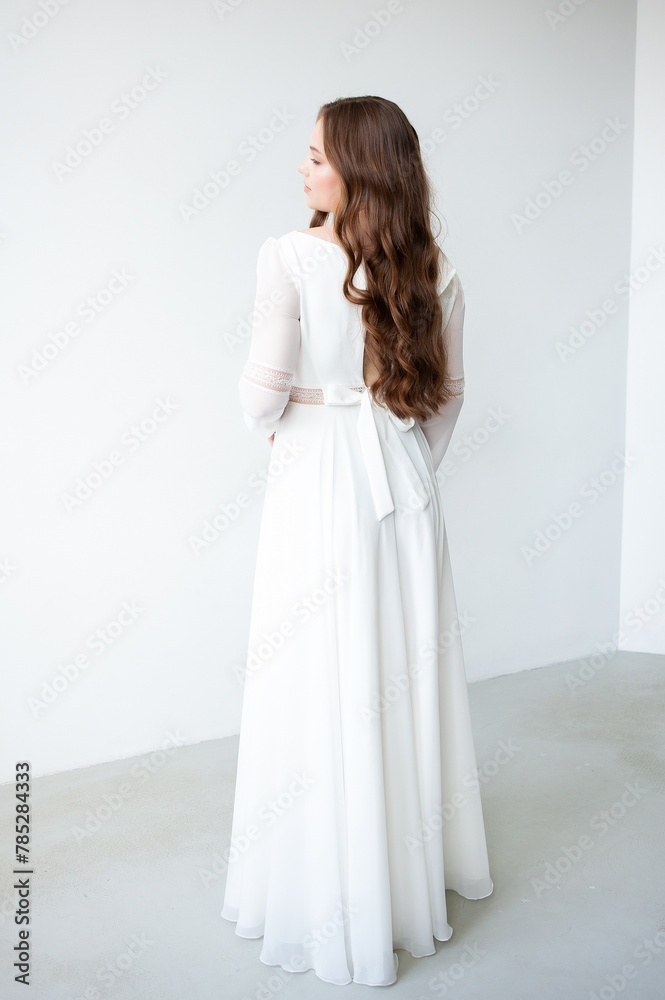 portrait of beautiful young woman in white wedding dress posing in studio. portrait of beautiful young woman in white wedding dress posing in studio.