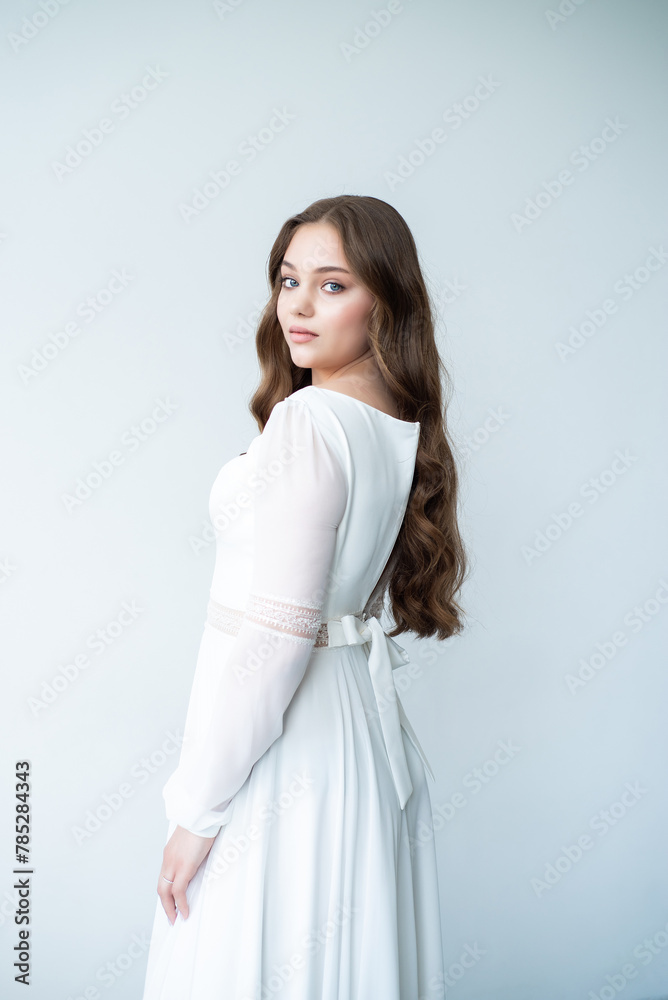 portrait of beautiful young woman in white wedding dress posing in studio. portrait of beautiful young woman in white wedding dress posing in studio.