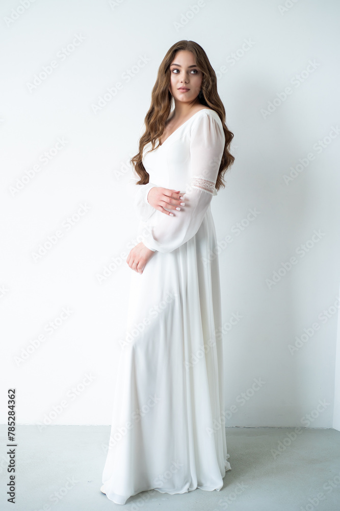 portrait of beautiful young woman in white wedding dress posing in studio. portrait of beautiful young woman in white wedding dress posing in studio.