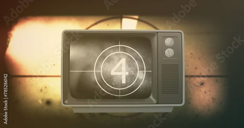 Image of film countdown in antique television over moving film reel in background