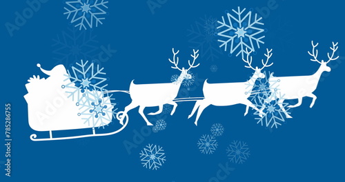 Image of white santa claus in sleigh with reindeer over snow falling on blue background