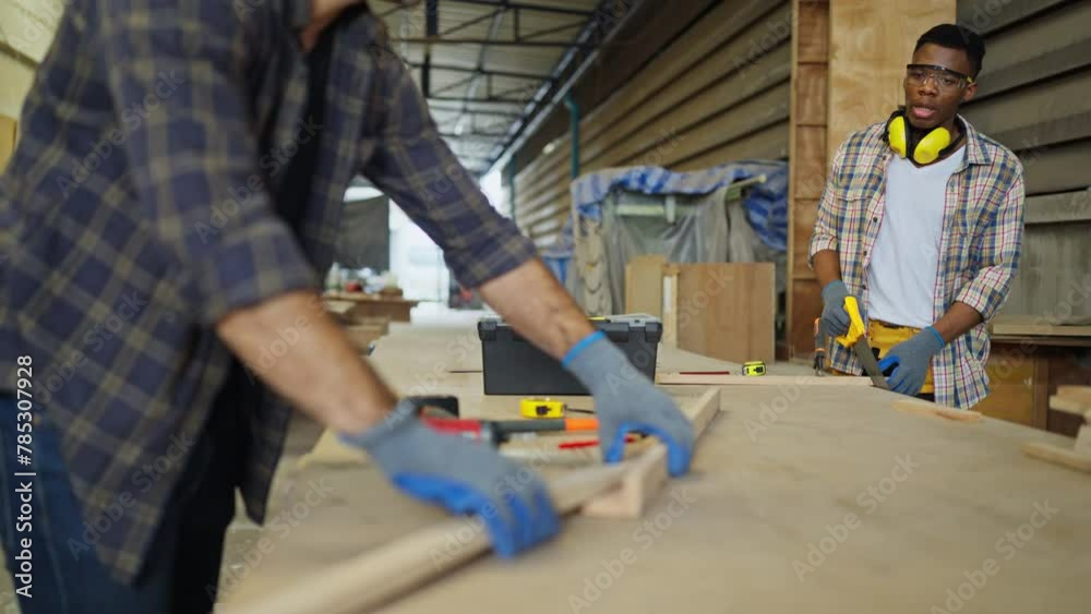 Caucasian carpenter or woodworker or charpentier man talk and discuss with his coworker in workplace during work with wood product.