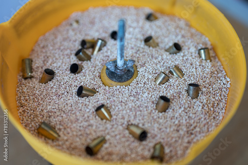 Detail of the walnut shell kernel cleaning the 9mm pods in a vibrating tumbler