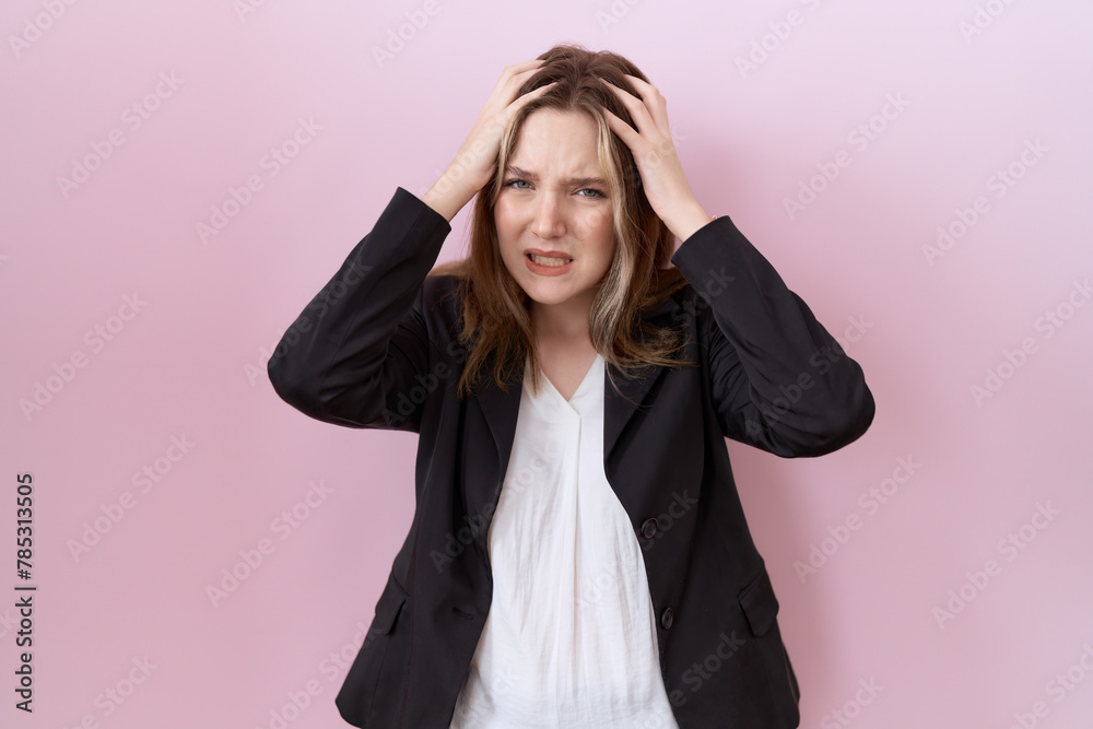 Young caucasian business woman wearing black jacket suffering from headache desperate and stressed because pain and migraine. hands on head.