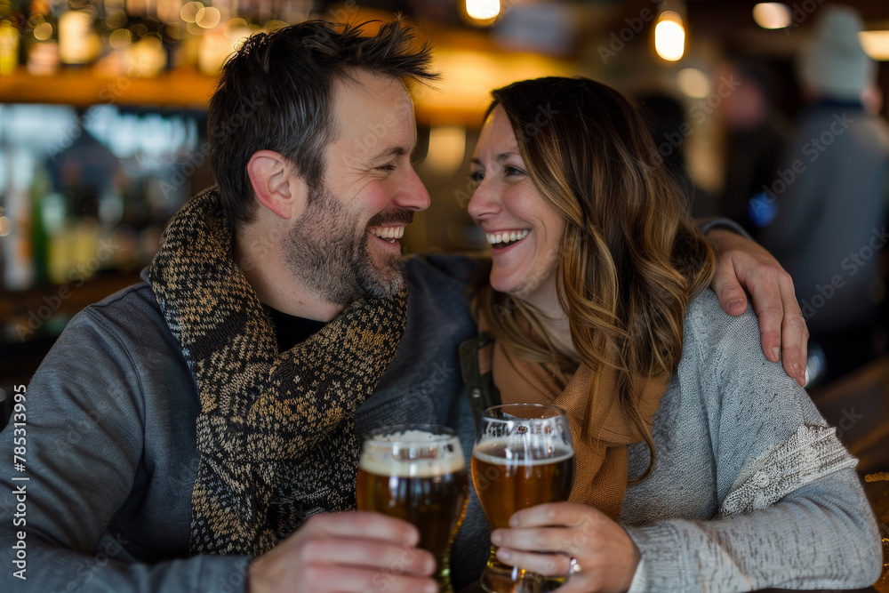 Happy couple enjoy drinking beer in bar laughing toasting anniversary celebration Happy couple enjoy drinking beer in bar laughing toasting anniversary celebration