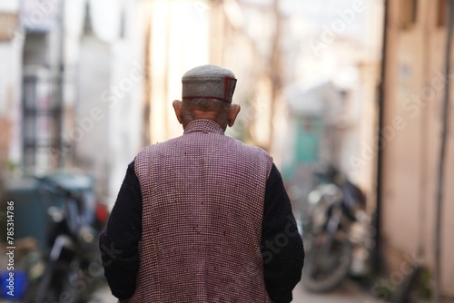 back view of an old man wearing himachali cap