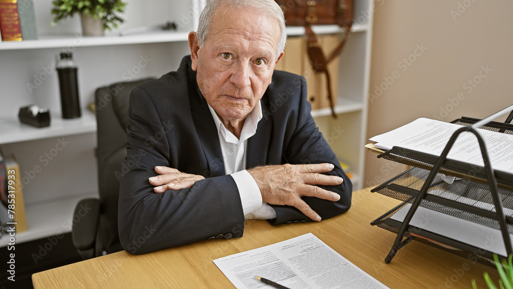 Captivating portrait of a serious senior man, a successful business worker, sitting in the office with a focused gaze, arms crossed – the epitome of mature confidence at work. Captivating portrait of a serious senior man, a successful business worker, sitting in the office with a focused gaze, arms crossed – the epitome of mature confidence at work.